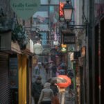 Peatones caminando bajo la lluvia en un día gris de invierno