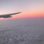 Vista desde la ventanilla de un avión sobrevolando las nubes